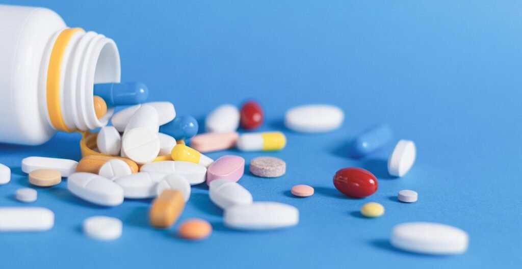 Compresse e capsule di vari colori fuoriescono da un flacone - rimedi per patologie