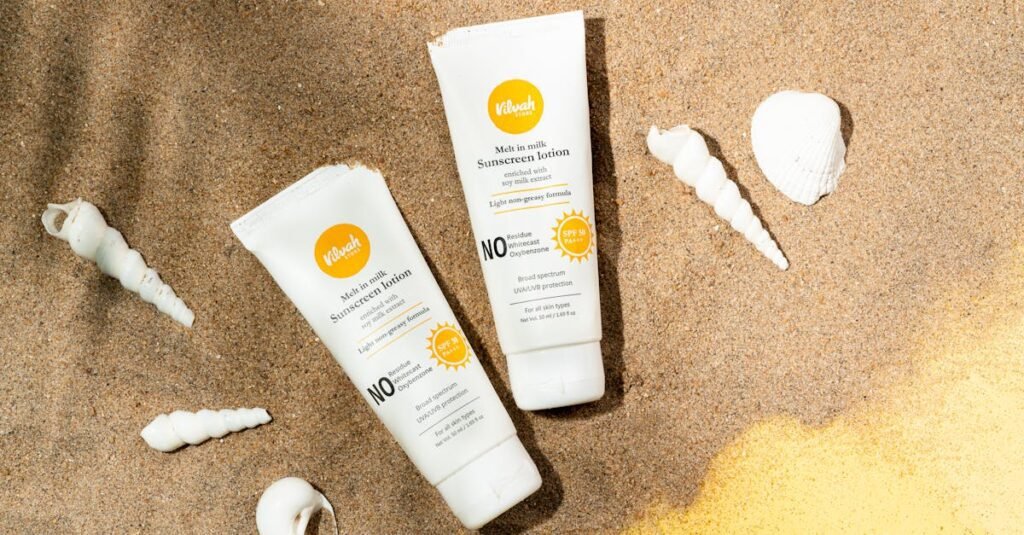 pexels-photo-16443631-16443631 Two sunscreen lotion tubes on sandy beach alongside seashells for sun protection imagery.