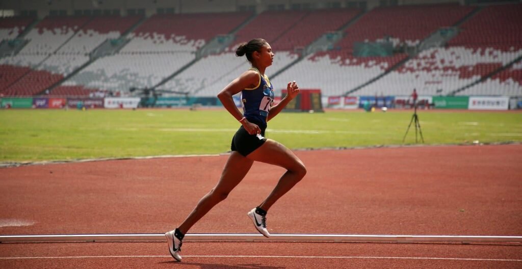 Immagine che mostra una atleta di corsa di fondo su pista, le cui prestazioni possono essere migliorate dalla caffeina
