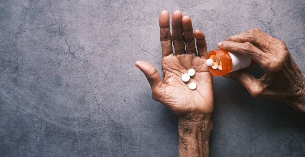 Immagine che illustra un anzianoche riempie la mano rugosa di compresse di integratori per trattare l'artrite